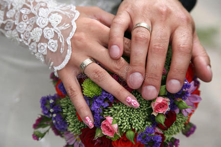 新娘和新郎的手靠近婚礼花束