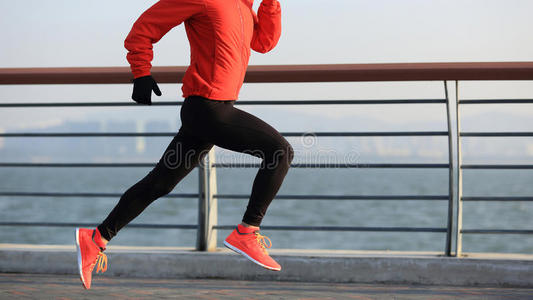 健身女子跑步者在日出海边跑步