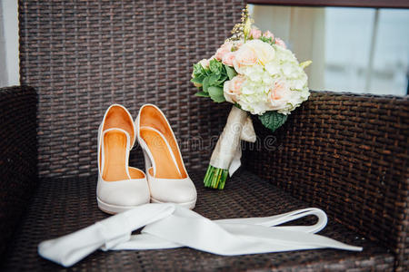 婚礼花束的特写玫瑰，婚礼花在床上，在酒店房间里穿着白色的鞋子