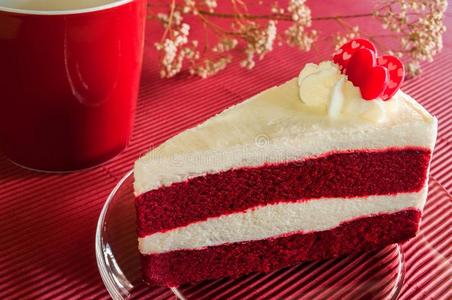 条形面包特写红色天鹅绒蛋糕与玻璃板在条形红纸上.照片