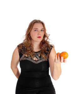 金发女人拿着两个橘子。
