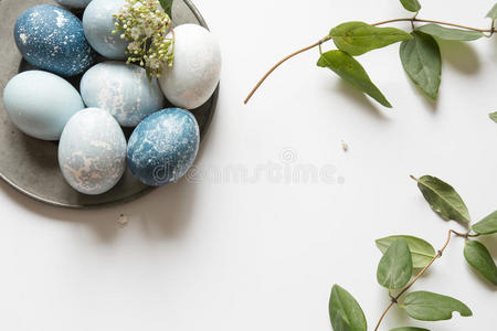 锡盘上的蓝色复活节彩蛋，装饰着鲜花
