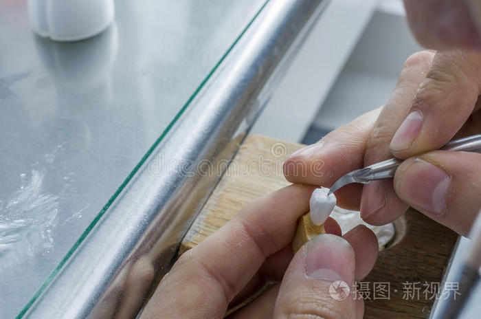 牙科技师在牙科模型中将陶瓷应用于牙齿