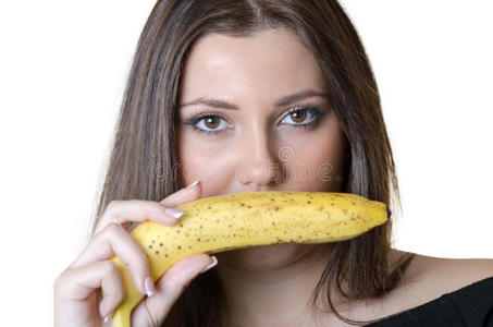 可爱的黑发女士穿黑色衬衫,拿着香蕉在持有一个女孩的肖像手不同水果