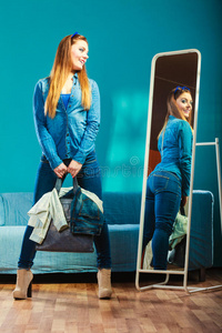 时尚女性在镜子前穿着蓝色牛仔布