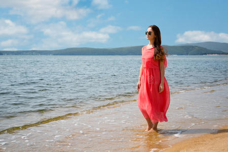 美丽的年轻女人站在沙滩上