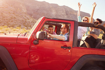 朋友们在公路旅行中驾驶敞篷车照片