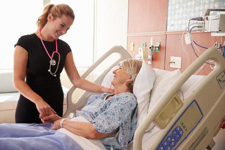 女医生在病床上与老年女性病人交谈