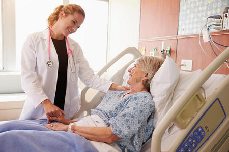 女医生在病床上与老年女性病人交谈