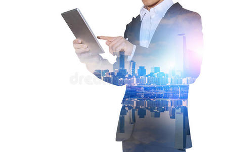 双曝光的商人持有平板电脑与城市景观模糊的背景。