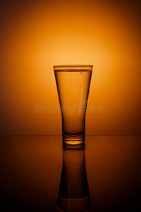 橙色背景上的一杯水