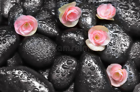 花和黑石头。 水疗概念。