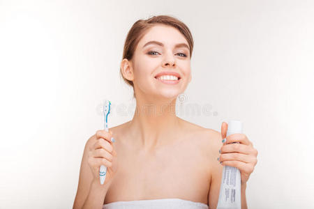 带牙膏和牙刷的开朗年轻女人的美丽肖像