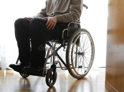 在年龄障碍在房间里坐轮椅的残疾老人照片