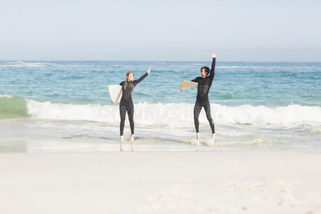 一对夫妇站在海滩上冲浪板