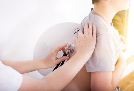 医生听男孩用听诊器心跳照片