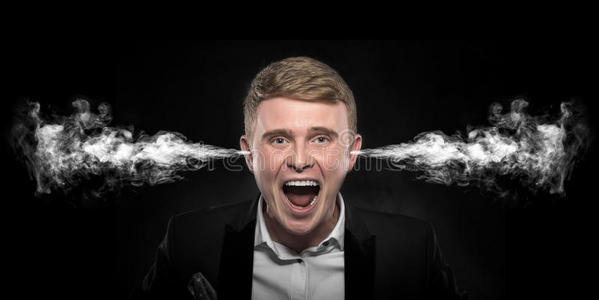 耳朵了愤怒的人从他的耳朵里冒了烟.照片