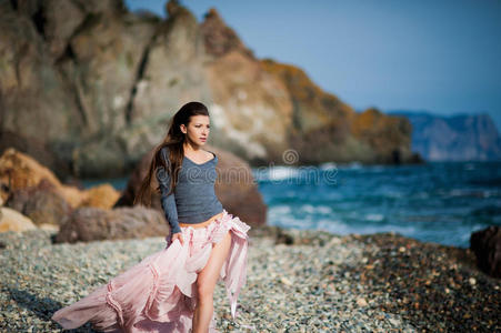 女孩在蓝天的背景下沿着海边奔跑