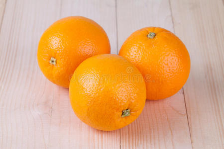 新鲜的三个橘子在木头上照片