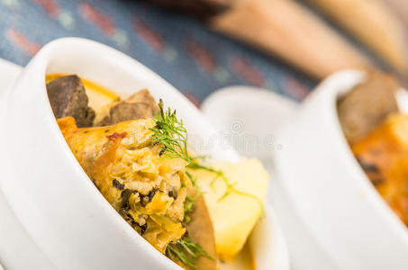 美味的土豆汤和肉和蔬菜，用白色碗端坐在桌子上，蓝色桌布，舒适