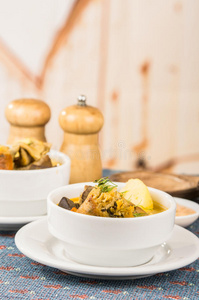 上等的土豆汤，配肉和蔬菜，用白色碗盛在桌子上，蓝色桌布，盐