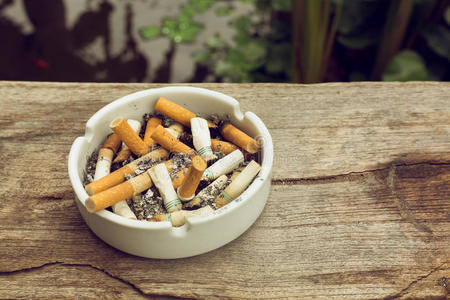 被烟雾困住的肺烟灰缸里的烟蒂照片