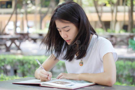 亚洲泰国中国学生大学美丽的女孩写了一本书.照片