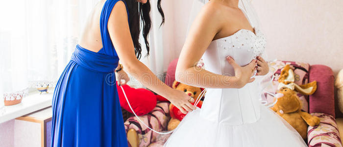 伴娘在帮新娘穿礼服