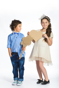 男孩和女孩抱着一颗纸板的心。 爱的概念