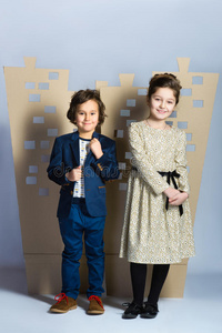 男孩和女孩抱着一个纸板镇。 爱的概念
