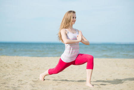 练习瑜伽的年轻女士。在海边锻炼。