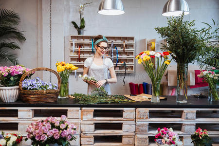 花店的美女开朗的美女花店老板微笑着在花店工作照片