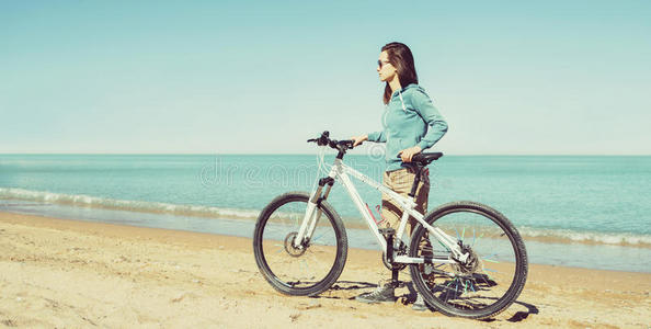 在海滩上骑自行车的女孩