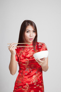 穿中国旗袍的亚洲女孩穿着筷子