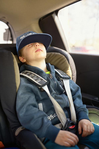 外国小孩子睡觉可爱的小孩子坐在安全的汽车座椅上睡觉照片