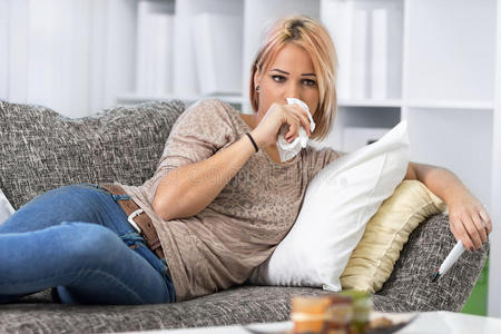 擦眼泪看悲伤电影的女孩用纸巾擦眼泪照片