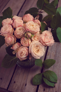 美丽的老式花束新鲜玫瑰在木板上