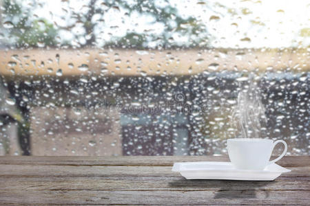 在雨天和早晨的阳光下喝咖啡杯