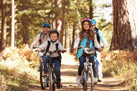 祖父母和孩子们骑自行车在森林小径上，加利福尼亚
