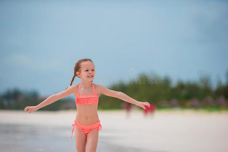 可爱的小女孩在海滩度假玩得开心