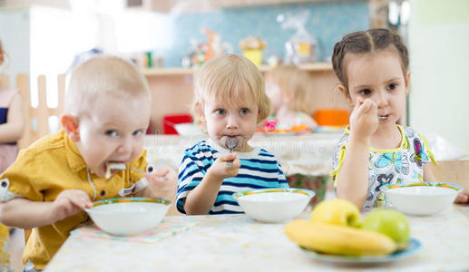儿童在日托中心用盘子吃饭