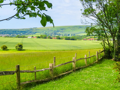 田野里的篱笆晚上山上山坡草地上的篱笆尖桩篱笆和维多利亚式住宅隔着