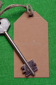 棕色纸标签附在绿色f上的金属银键上