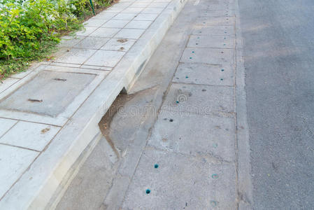 排水排水沟在道路上,旁边的人行道照片