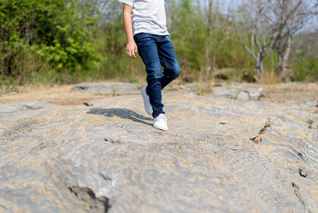 男孩走在岩石上.照片