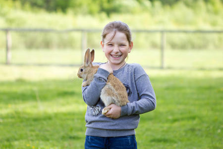 欢快的小女孩抱着一只真正的兔子