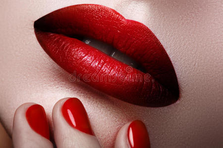 女性嘴唇的特写与时尚化妆和指甲。 波