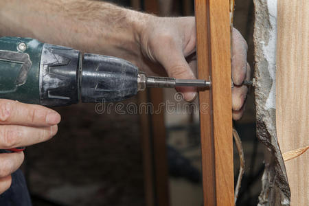 木匠用无绳电钻在门口固定Jam