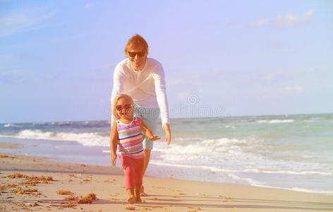 爸爸和小女儿在海滩玩