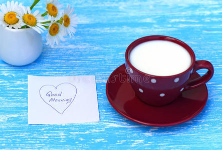 雏菊花和一杯牛奶和早上好的便条